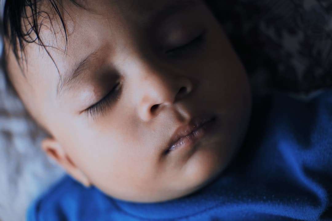 a close up of a baby sleeping on a bed