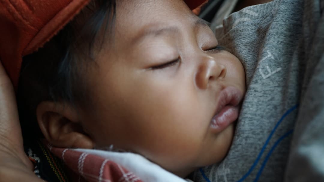 A sleeping baby is snuggling close.