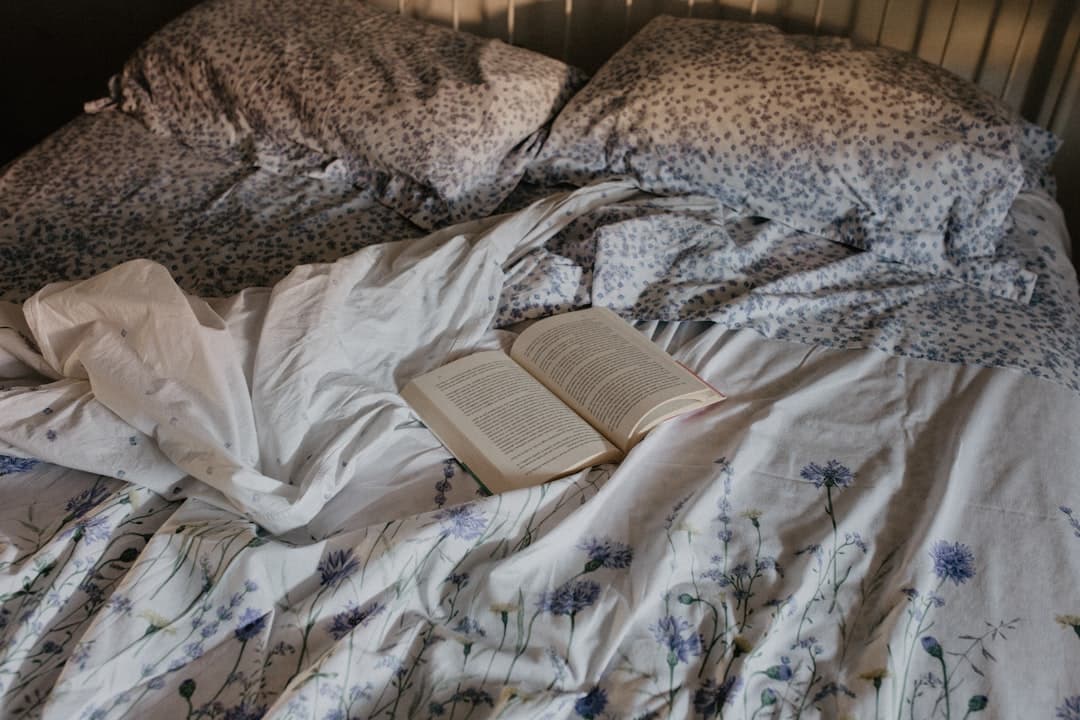an open book is laying on a messy bed